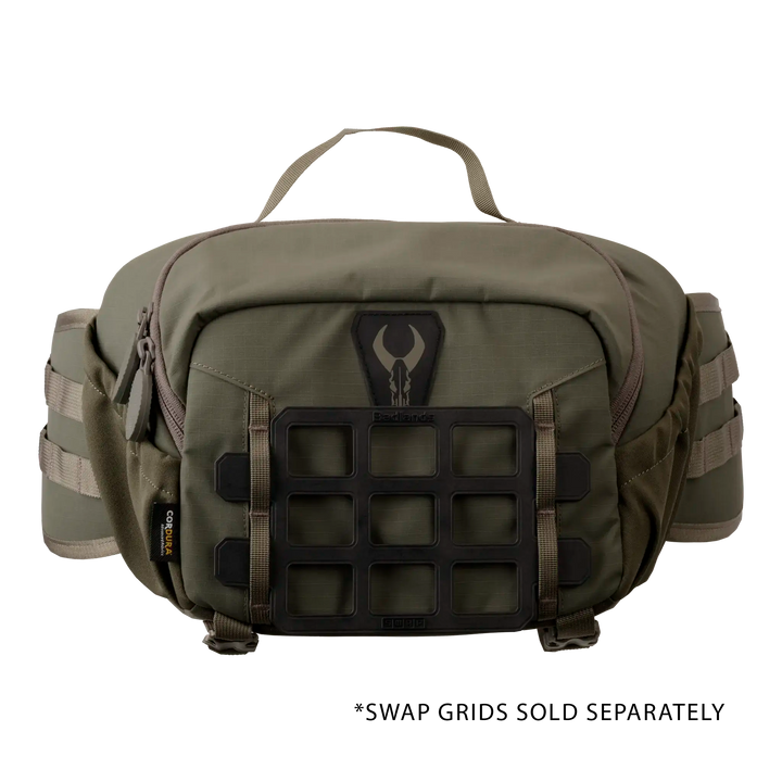 Olive Badlands waist pack with skull logo, top handle, MOLLE panel, and side straps, designed for outdoor gear organization.