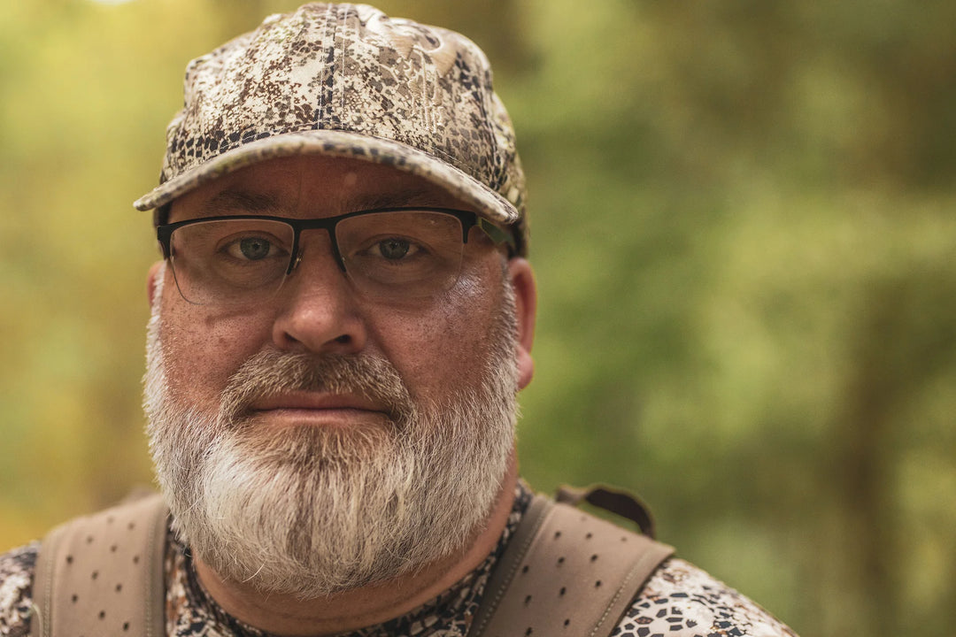 Person in Badlands camo gear outdoors; Badlands skull logo visible on shoulder strap.