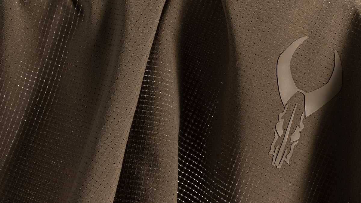 Brown ripstop fabric with the Badlands skull logo embossed on the right side. Subtle grid pattern for texture.
