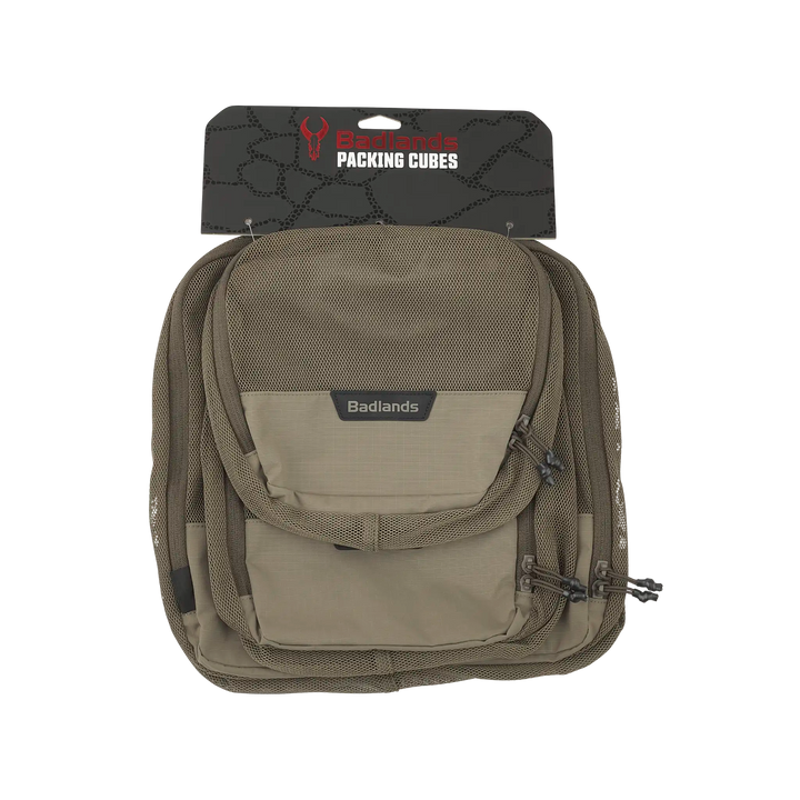 Tan Badlands packing cubes with logo skull, mesh pocket, and zippers, designed for organized gear storage.