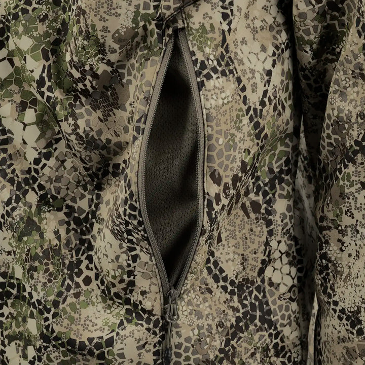 Close-up of Badlands camo fabric with a zippered pocket, showing textured mesh lining for breathability and storage.