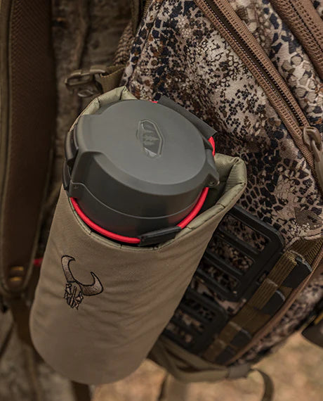 Badlands backpack with logo; water bottle in side pouch, camo pattern, outdoor gear, close-up view.