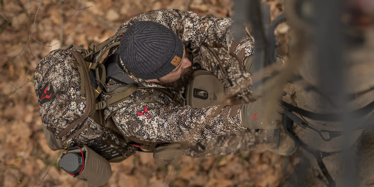 Hunter in Badlands camo climbs a tree stand; Badlands skull logo visible on gear and clothing.