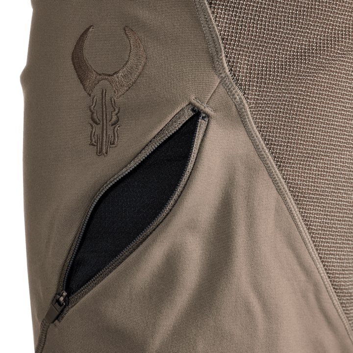 Close-up of a Badlands jacket pocket with the embroidered Badlands skull logo above the zippered opening.