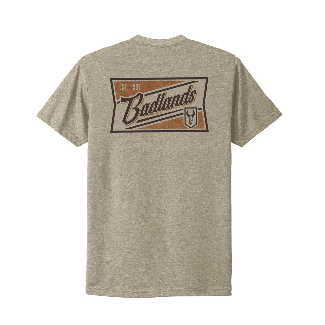 Tan Badlands t-shirt with large logo, "Est. 1992," and skull emblem on back. High-contrast, easy-to-read design.