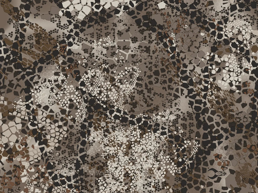 Mosaic camo pattern in earth tones with a subtle Badlands skull logo, designed for effective concealment in rugged terrain.