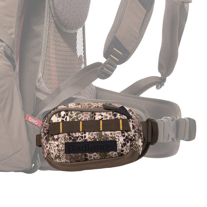 Badlands camo waist pack with logo, attached to a backpack hip belt for easy access during outdoor activities.