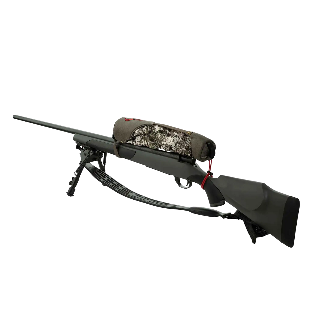 Badlands camo rifle case with skull logo, secured on a black hunting rifle with bipod, isolated on white background.