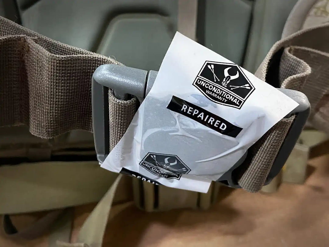 Badlands pack buckle with "Unconditional Warranty Repaired" tag featuring the Badlands skull logo.