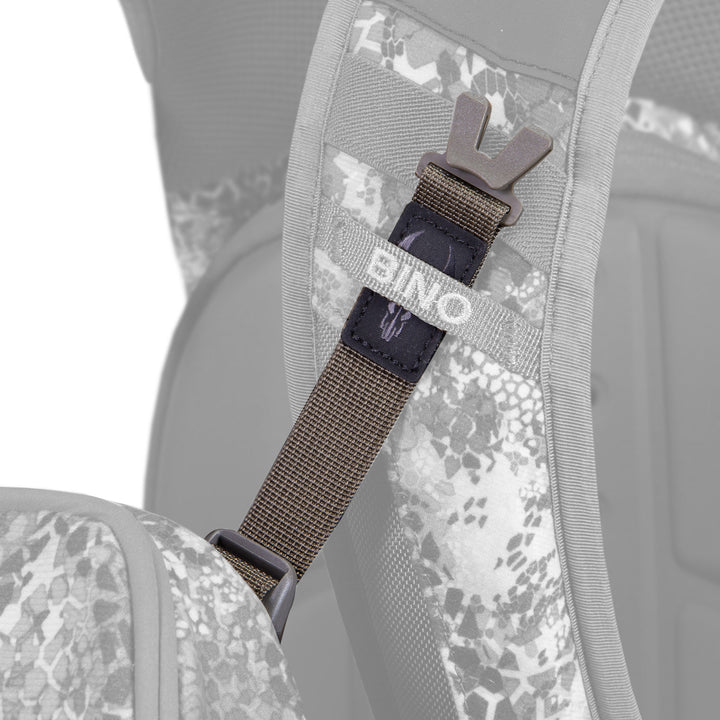 Close-up of a Badlands backpack strap with "BINO" label and Badlands skull logo, showing adjustable buckle and camo pattern.