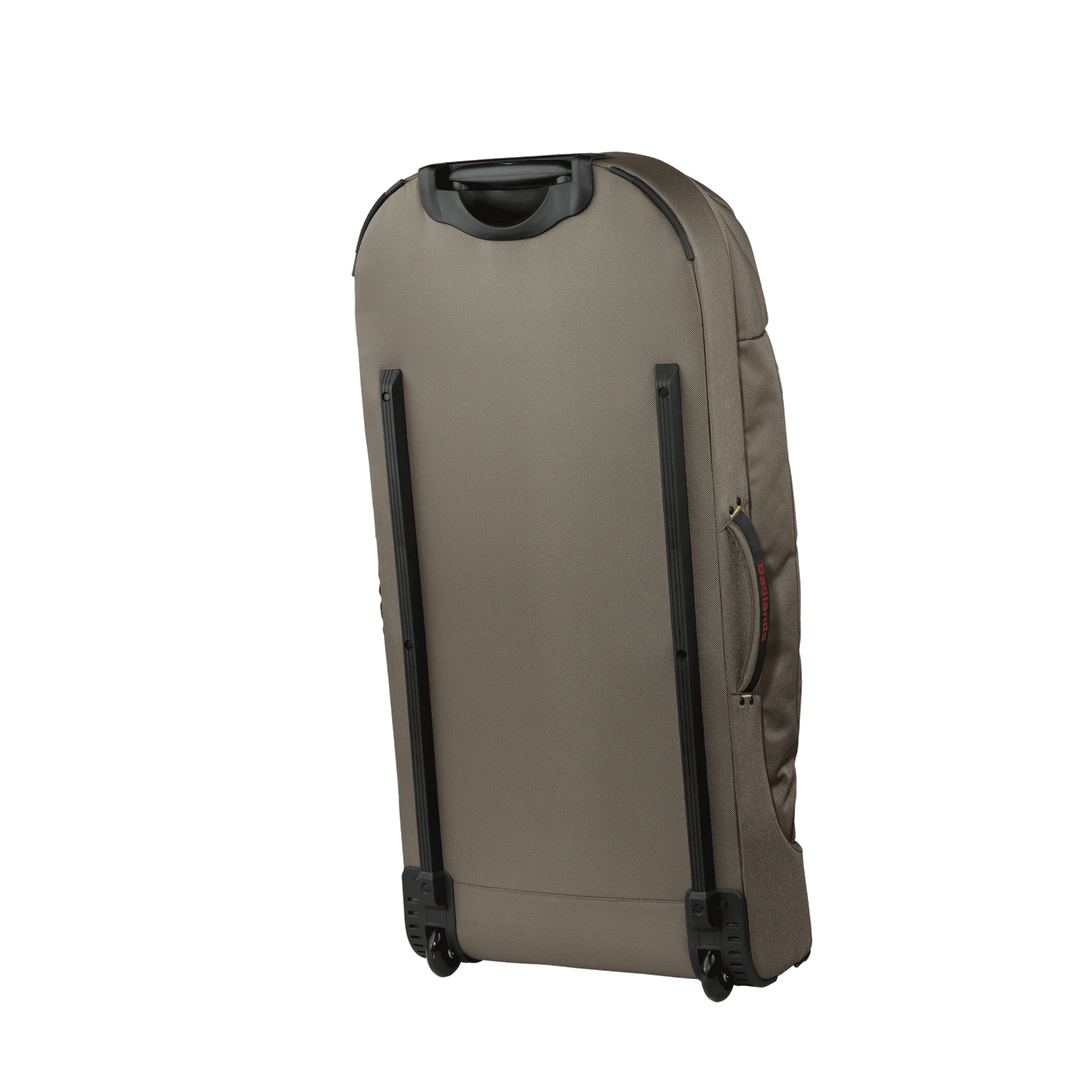 Tan rolling suitcase with black handle and wheels, shown from the back; accessible side handle for easy transport.