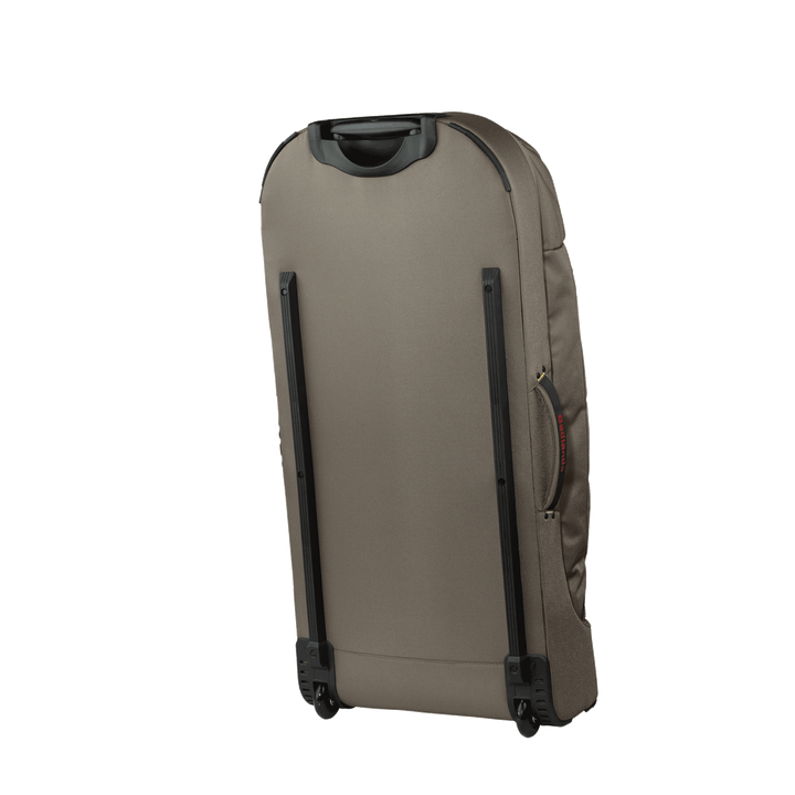 Tan rolling suitcase with black handle and wheels, shown from the back; accessible side handle for easy transport.