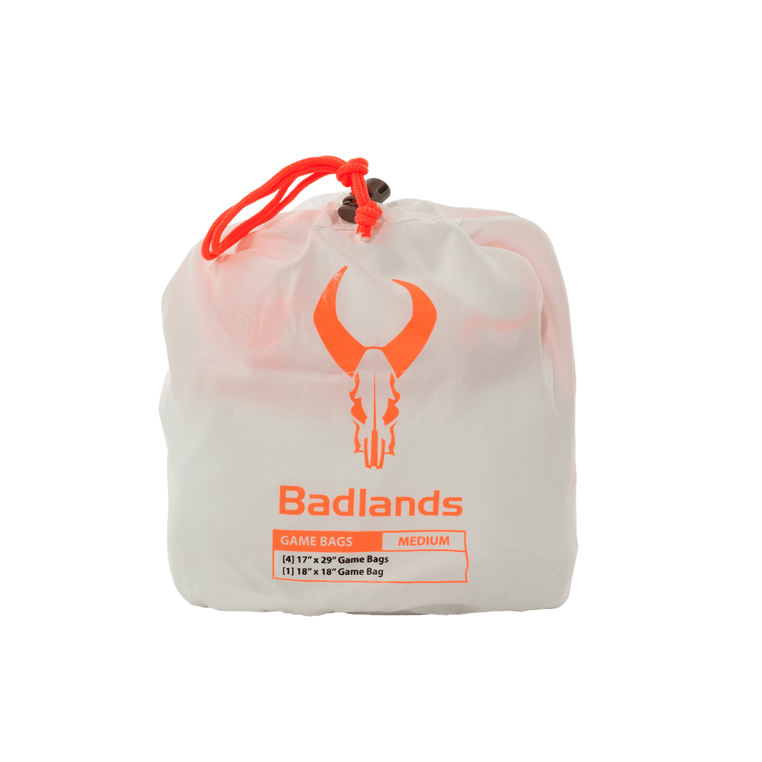 White Badlands game bag set with orange skull logo and drawstring, labeled medium, for storing hunting game.
