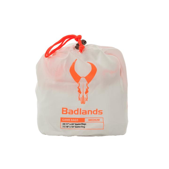 White Badlands game bag set with orange skull logo and drawstring, labeled medium, for storing hunting game.