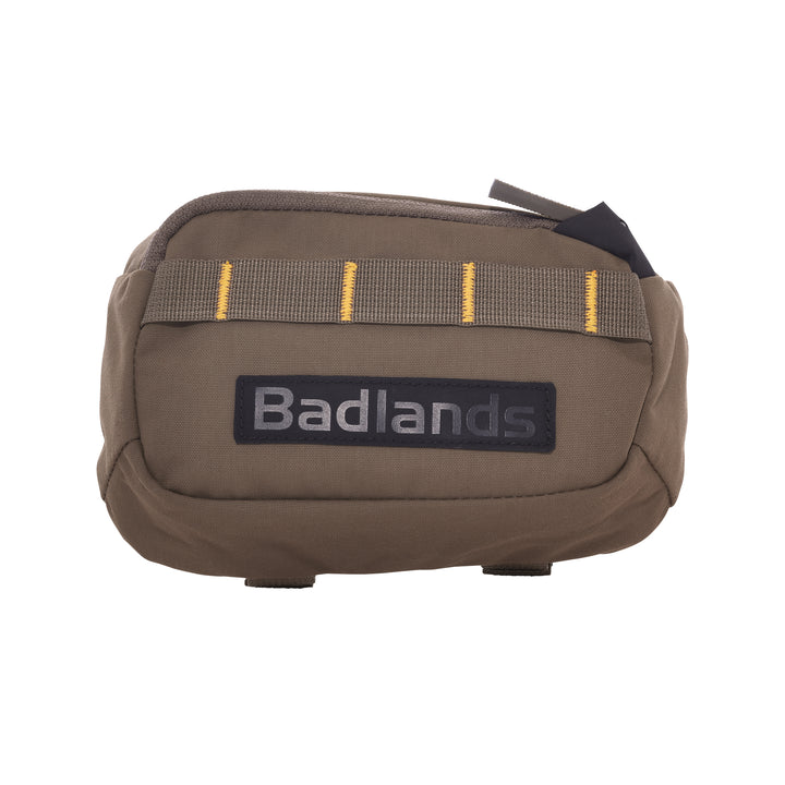 Tan Badlands pouch with yellow-stitched webbing and a black Badlands logo patch on the front, zipper closure on top.