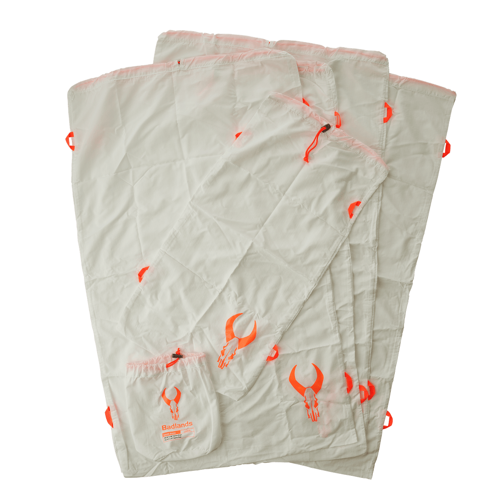 Lightweight Badlands blanket with orange skull logo, designed for outdoor use; includes attached storage pouch.