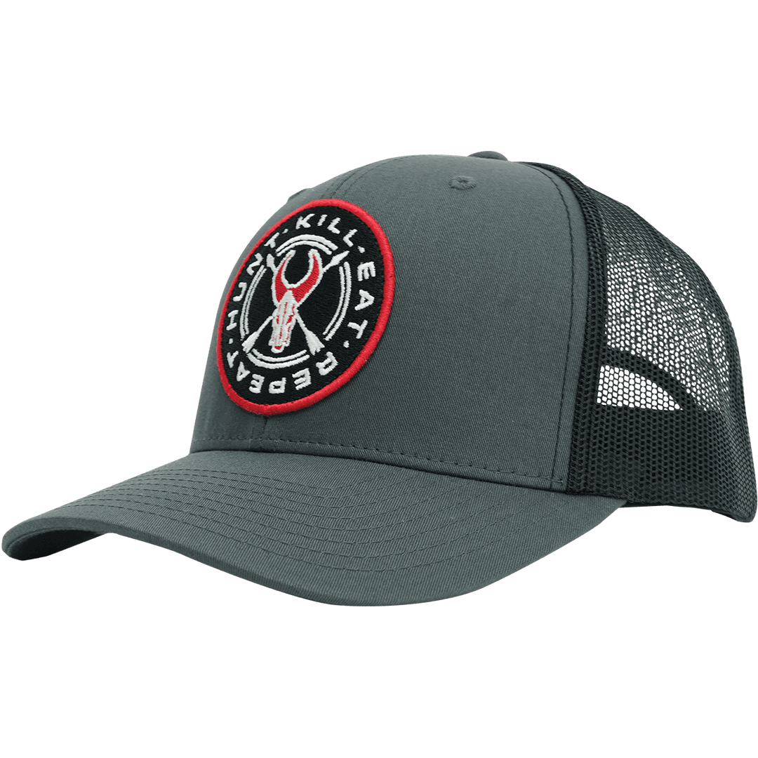 Gray Badlands trucker hat with mesh back and round logo patch featuring a skull and "Hunt. Kill. Eat. Repeat." text.